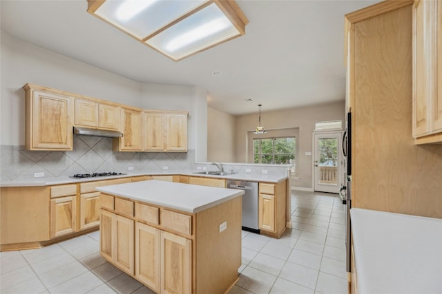 kitchen with light brown cabinetry, stainless steel dishwasher, and a sink