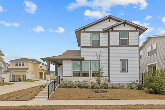 view of front of home with stone siding, fence, and concrete driveway