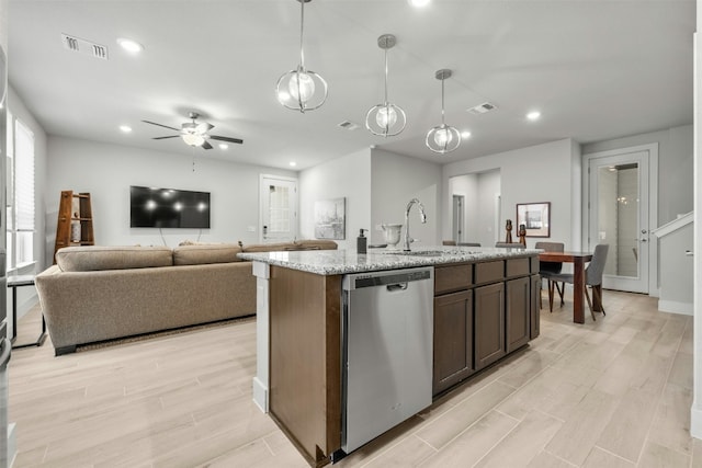 kitchen featuring visible vents, dishwasher, light wood-style flooring, and a sink