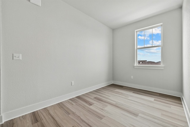 spare room with light wood-type flooring and baseboards