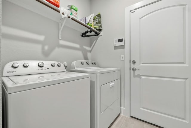 clothes washing area featuring laundry area, wood tiled floor, and washing machine and clothes dryer