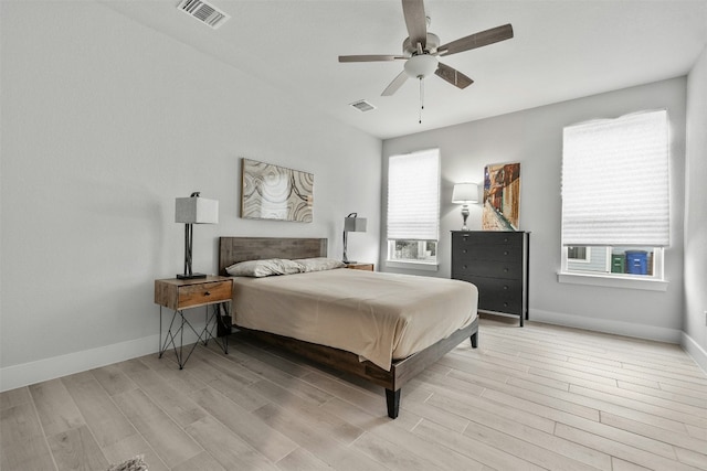 bedroom featuring light wood-type flooring, visible vents, and baseboards