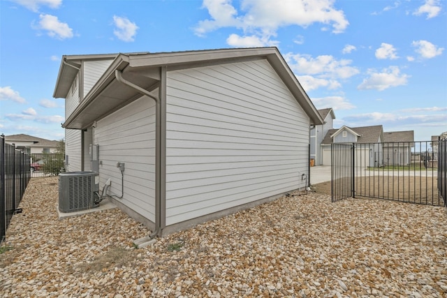 view of side of home with cooling unit and fence