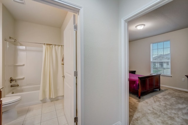 bathroom with toilet, tile patterned flooring, baseboards, and shower / tub combo with curtain