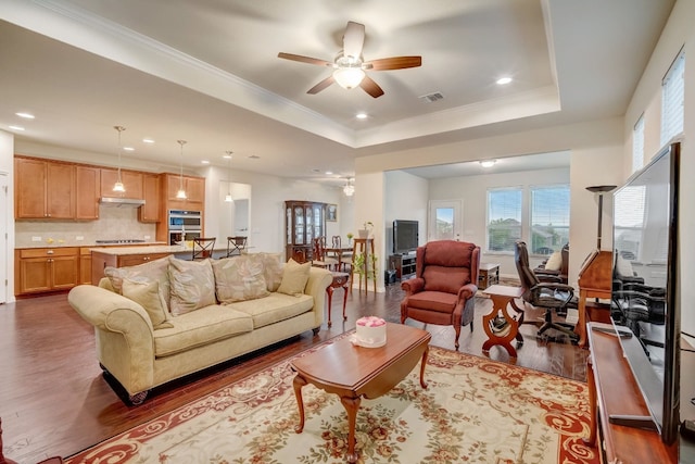 living room featuring a raised ceiling, visible vents, and dark wood-style flooring