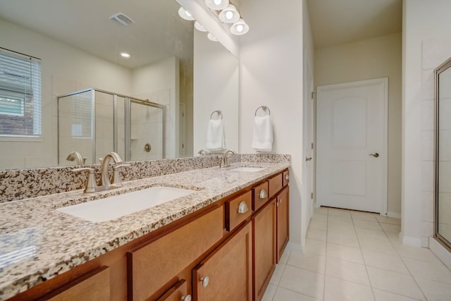 bathroom with double vanity, a stall shower, a sink, and visible vents