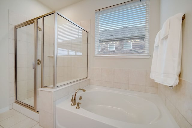 bathroom featuring a stall shower, tile patterned flooring, and a garden tub