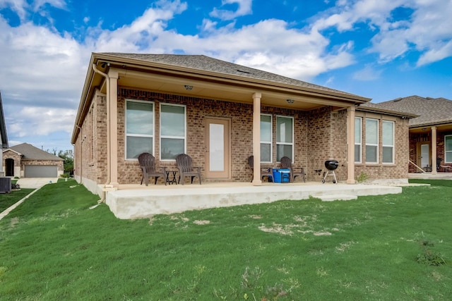 back of property featuring a yard, brick siding, a patio, and central AC unit