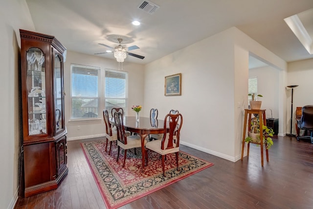 dining area with baseboards, visible vents, ceiling fan, and dark wood-style flooring