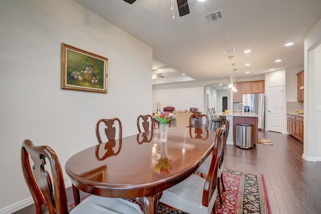 dining area featuring arched walkways, recessed lighting, visible vents, a ceiling fan, and dark wood-type flooring