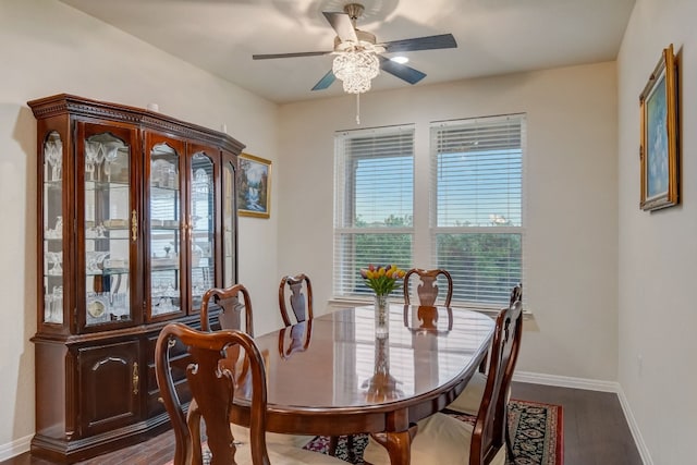 dining space with dark wood-style flooring, a ceiling fan, and baseboards