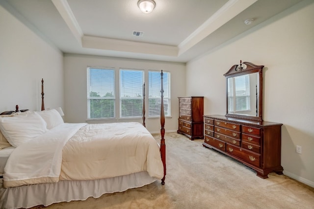 bedroom with baseboards, visible vents, light colored carpet, a tray ceiling, and crown molding