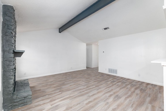 unfurnished living room with visible vents, vaulted ceiling with beams, baseboards, and wood finished floors