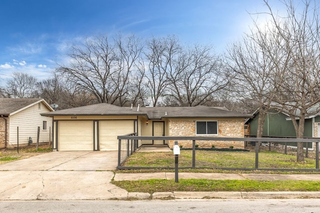 view of front facade with stone siding, concrete driveway, a fenced front yard, and an attached garage