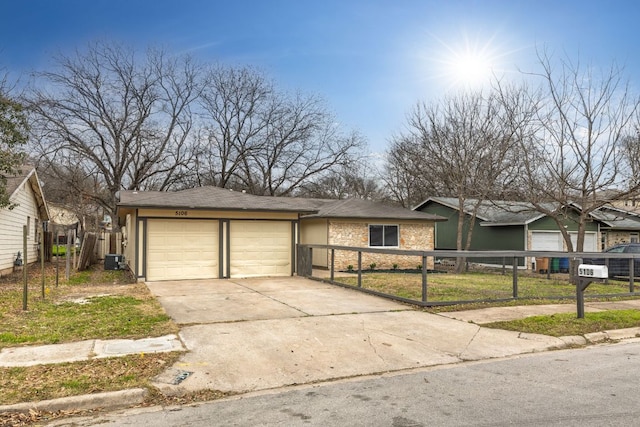 view of front of home featuring a fenced front yard, concrete driveway, stone siding, and an attached garage