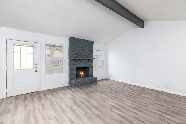 unfurnished living room with vaulted ceiling with beams, light wood finished floors, a fireplace, and baseboards