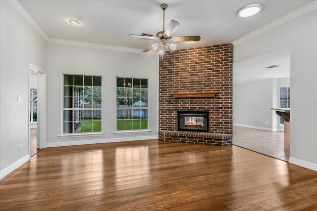 503 Riverview Dr, Georgetown, TX 78628 - unfurnished living room with ornamental molding, wood finished floors, ceiling fan, and a fireplace