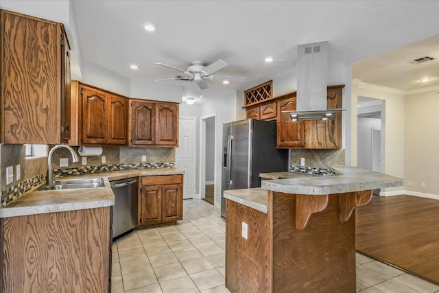 503 Riverview Dr, Georgetown, TX 78628 - kitchen with appliances with stainless steel finishes, island exhaust hood, a peninsula, a breakfast bar area, and decorative backsplash