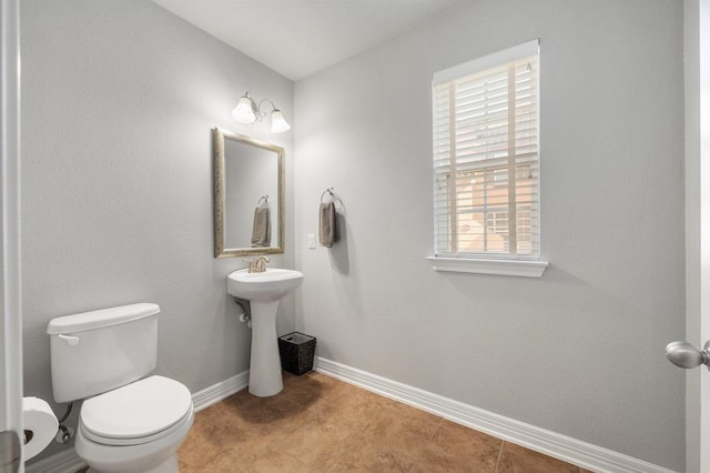 bathroom featuring baseboards and toilet