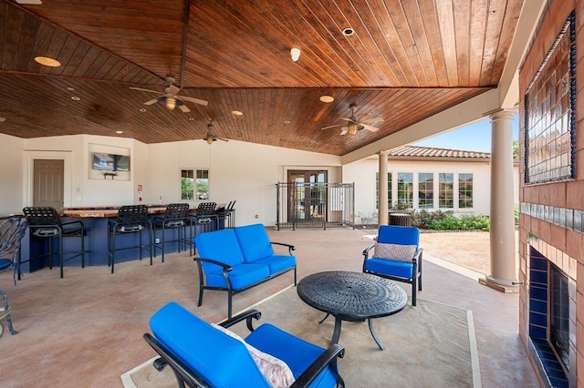 view of patio with exterior bar, a ceiling fan, and outdoor lounge area