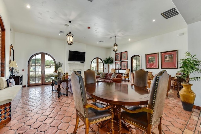 dining area with french doors, a fireplace, visible vents, and recessed lighting