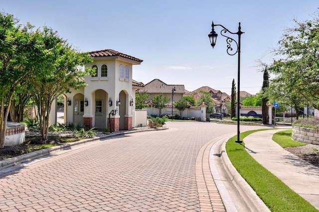 view of road featuring street lights, sidewalks, and curbs