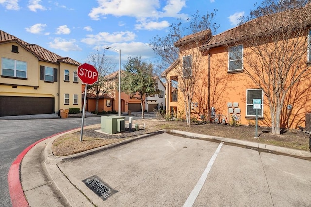 view of street featuring traffic signs, a residential view, and curbs