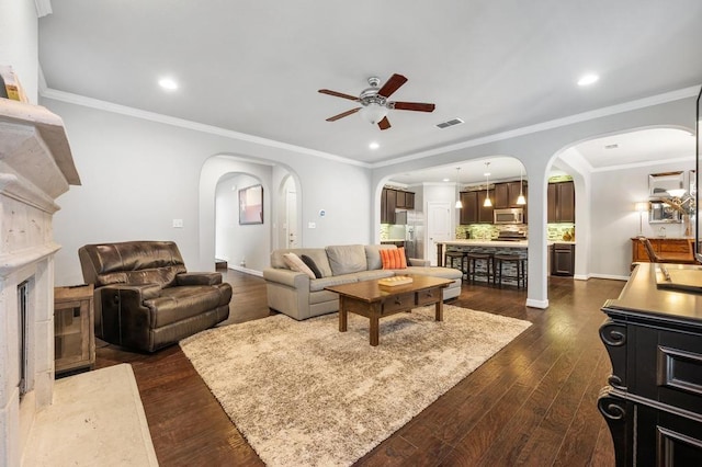 living room with a ceiling fan, arched walkways, dark wood-type flooring, and recessed lighting