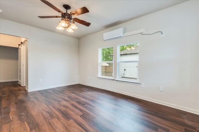 spare room with ceiling fan, baseboards, an AC wall unit, and wood finished floors