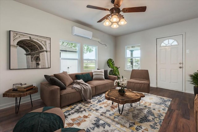 living area featuring a ceiling fan, baseboards, wood finished floors, and a wall mounted AC