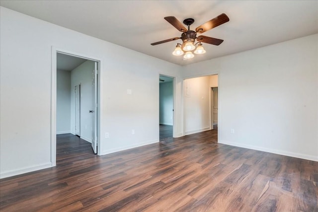 empty room with a ceiling fan, baseboards, and dark wood-style flooring