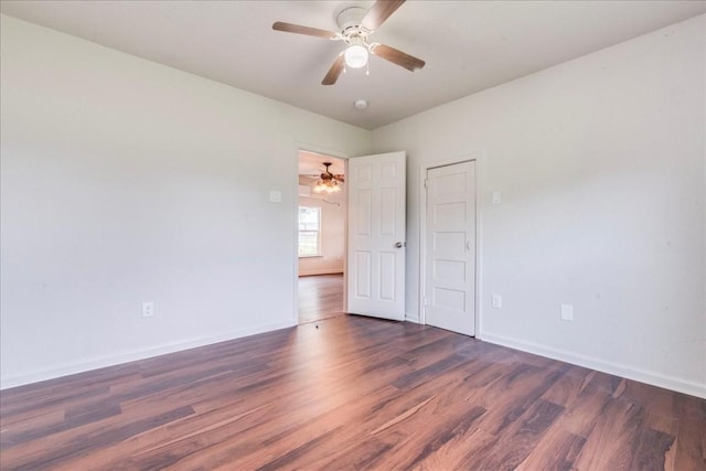 empty room featuring ceiling fan, baseboards, and wood finished floors