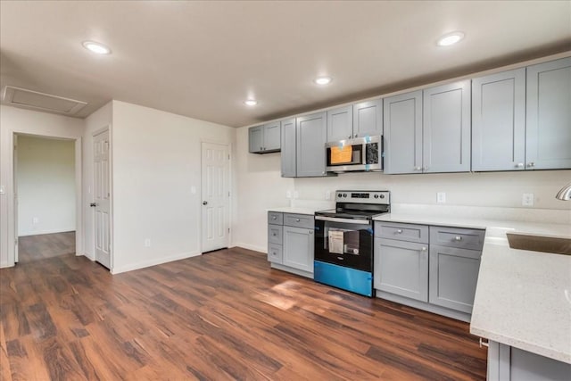 kitchen with dark wood-style floors, recessed lighting, appliances with stainless steel finishes, and gray cabinetry
