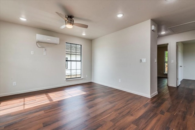 spare room with a ceiling fan, baseboards, dark wood-style flooring, and a wall mounted air conditioner