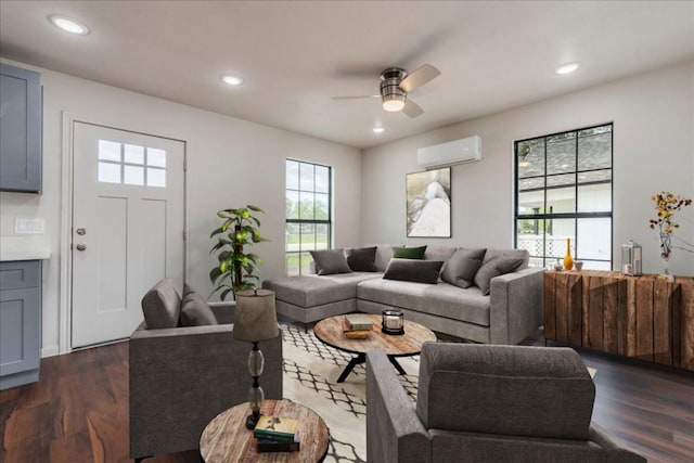 living room with dark wood-style floors, recessed lighting, and an AC wall unit