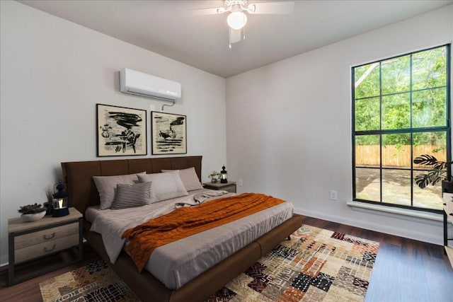 bedroom featuring baseboards, a ceiling fan, an AC wall unit, and wood finished floors