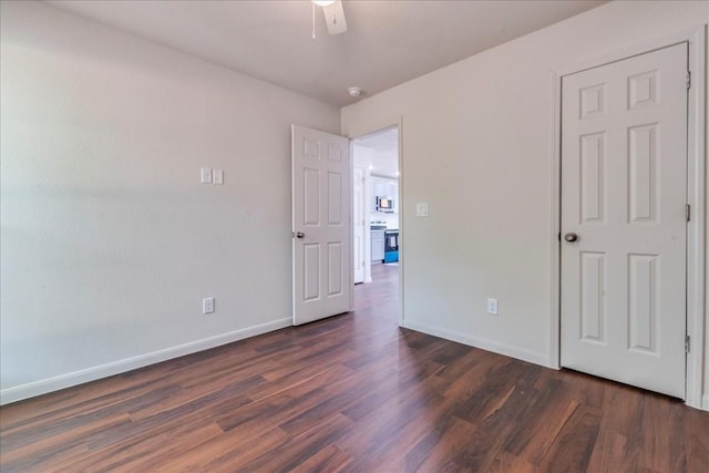 unfurnished bedroom with dark wood-style flooring, ceiling fan, and baseboards