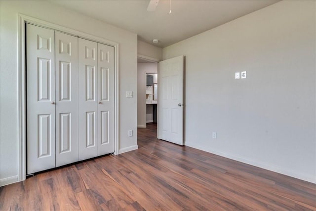 unfurnished bedroom featuring a closet, wood finished floors, a ceiling fan, and baseboards