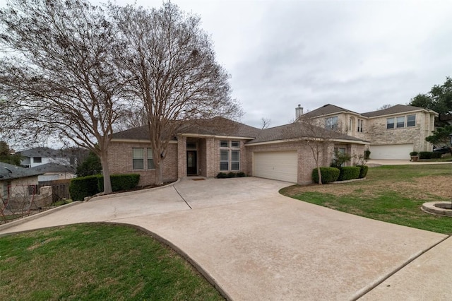 view of front of property featuring driveway, an attached garage, a front yard, and brick siding