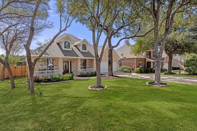 view of front of home featuring driveway, a front lawn, an attached garage, and fence