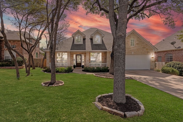 view of front of home with driveway, a garage, roof with shingles, covered porch, and a front yard