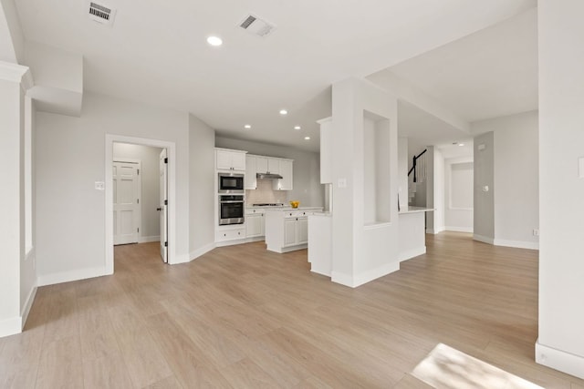 unfurnished living room featuring light wood-type flooring, stairs, visible vents, and recessed lighting