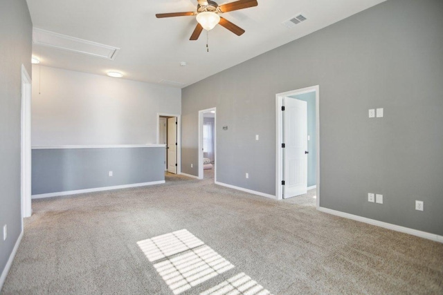 empty room featuring attic access, baseboards, visible vents, ceiling fan, and carpet flooring