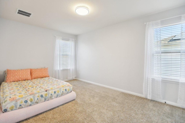 carpeted bedroom with visible vents and baseboards