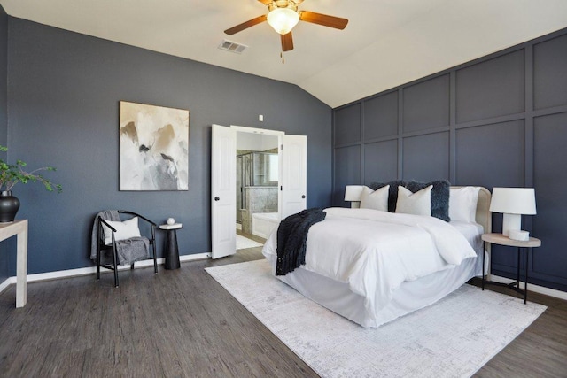 bedroom featuring lofted ceiling, visible vents, a decorative wall, dark wood-type flooring, and baseboards