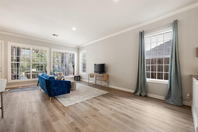 unfurnished living room featuring light wood-type flooring, visible vents, crown molding, and baseboards