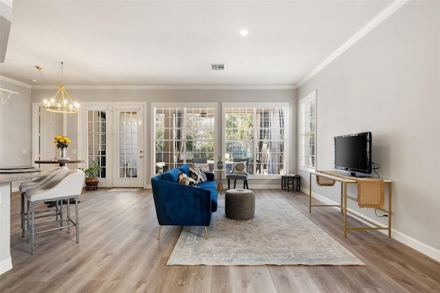 living room with an inviting chandelier, wood finished floors, visible vents, and baseboards