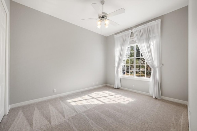 empty room with carpet floors, baseboards, and a ceiling fan