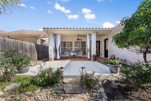 back of property featuring a ceiling fan, a tile roof, fence, a wooden deck, and stucco siding