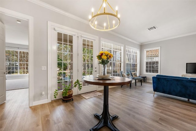 dining area with crown molding, visible vents, and wood finished floors